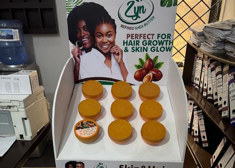 A Zyn Refined Shea Butter floor stand stocked with tubs of product.