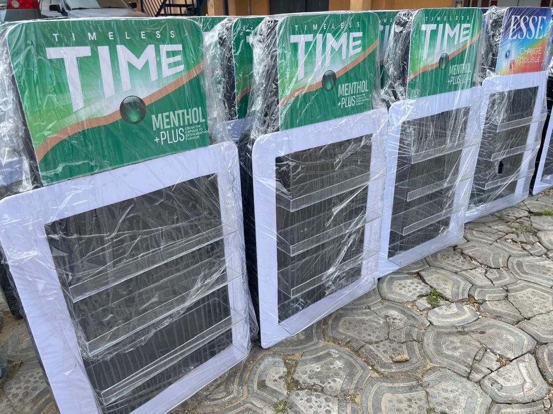 A row of green Time Menthol Plus counter displays wrapped and standing on paving.