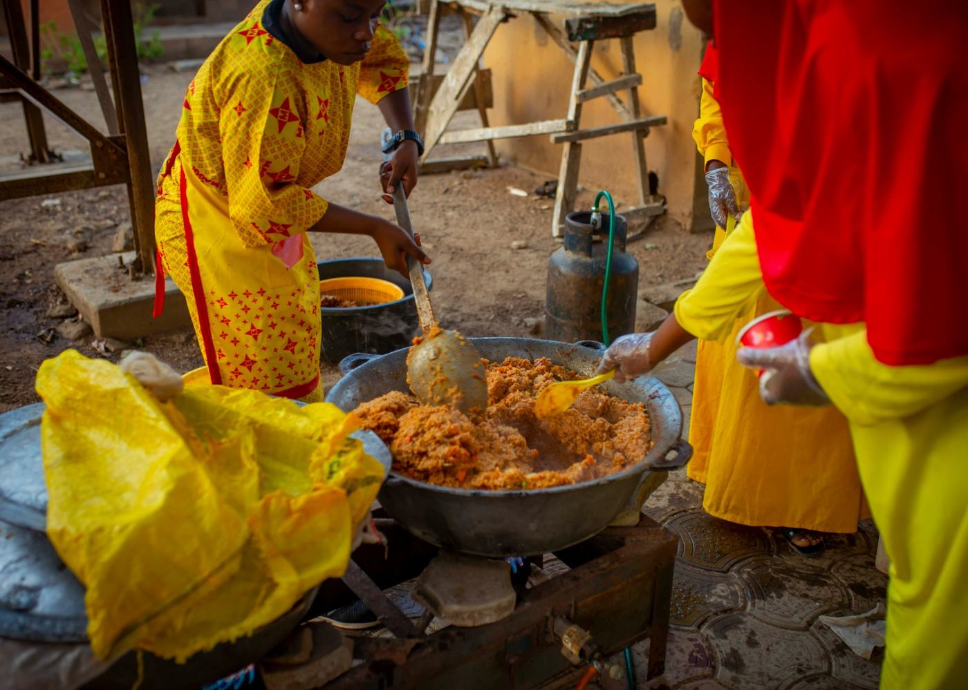 The field kitchen team cooking the evening meal in a large pot on site.