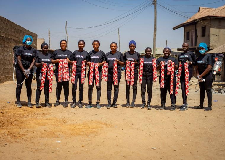The Nescafe field team lined up on a neighbourhood street holding sachet strips.