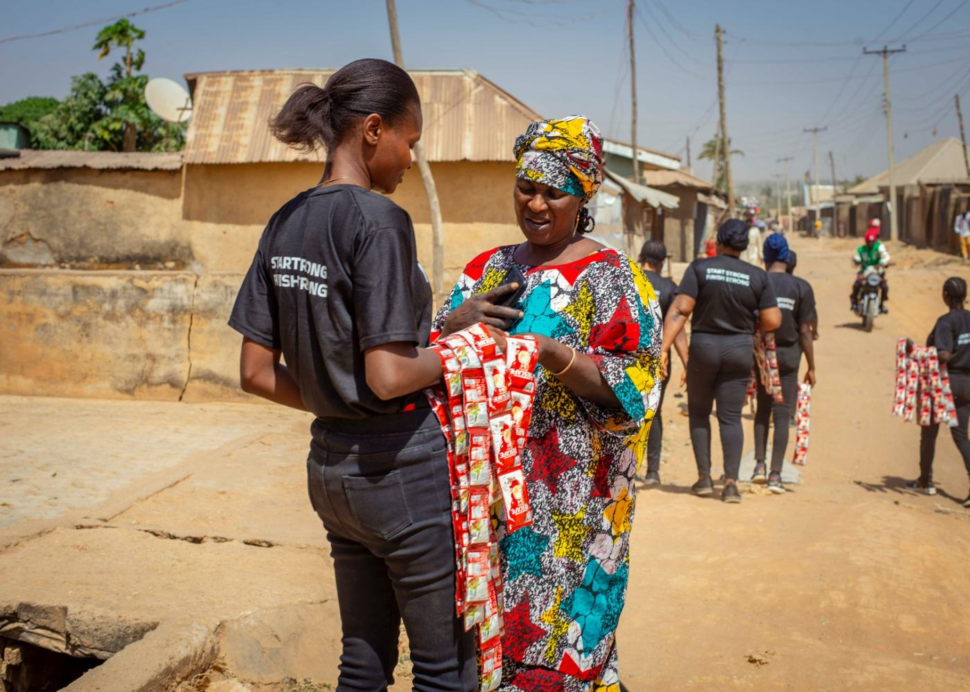 An ambassador engaging a woman in ankara on a neighbourhood street.