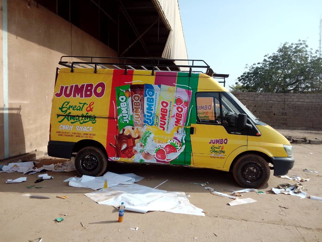 A yellow van fully wrapped in Jumbo Great and Amazing corn snack artwork.